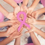 Women Hands Holding Pink Breast Cancer Ribbon Standing Together