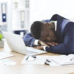 Tired black businessman sleeping in his office