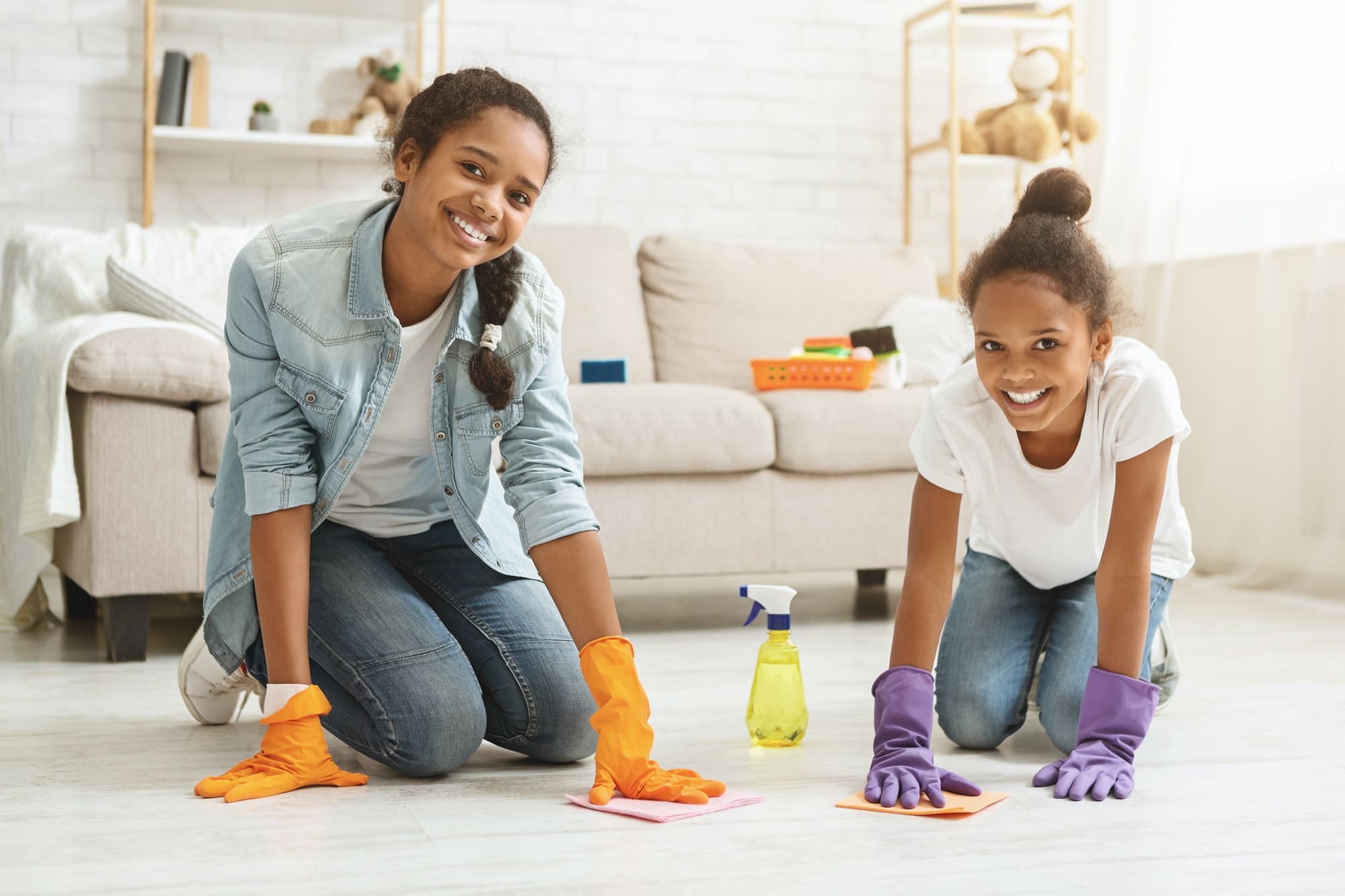 Two adorable girls cleaning carpet at home