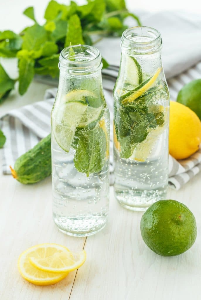 Infused water with citrus and mint in glass bottles