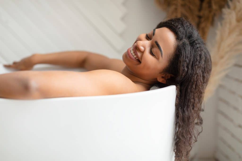 Black Woman Taking Bath Relaxing Lying In Bathtub In Bathroom